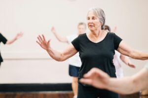 Elderly women enjoying a fitness group exercise session indoors.